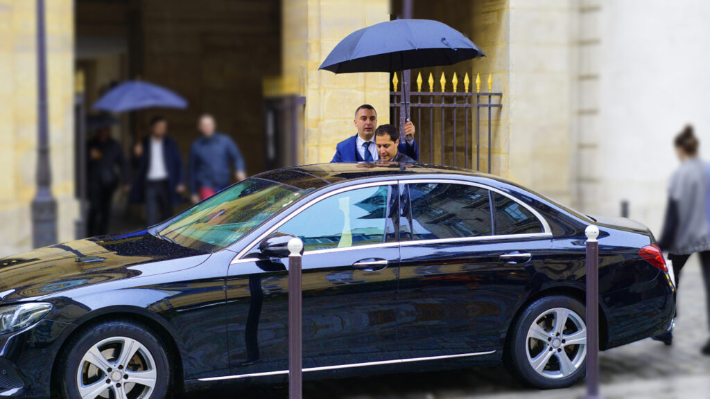 Sam driver in Paris holding umbrella in rainy day while MATAHAFI getting in the car